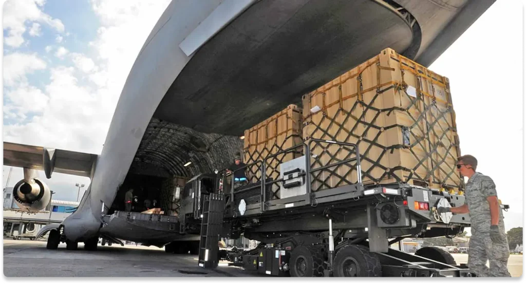 Army men loading a plane with freight cargo
