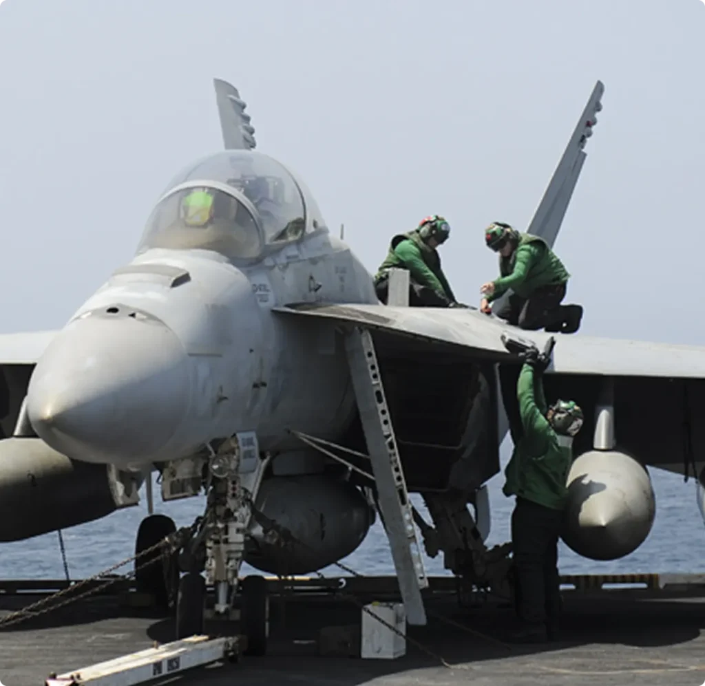 Armed forces mechanics working on a fighter jet plane