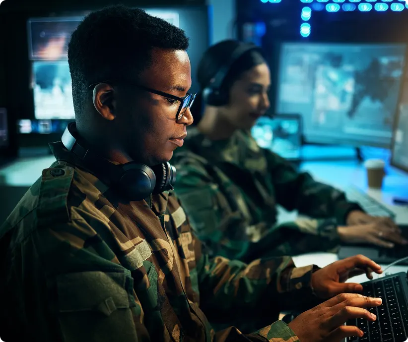 man wearing fatigues typing on computer