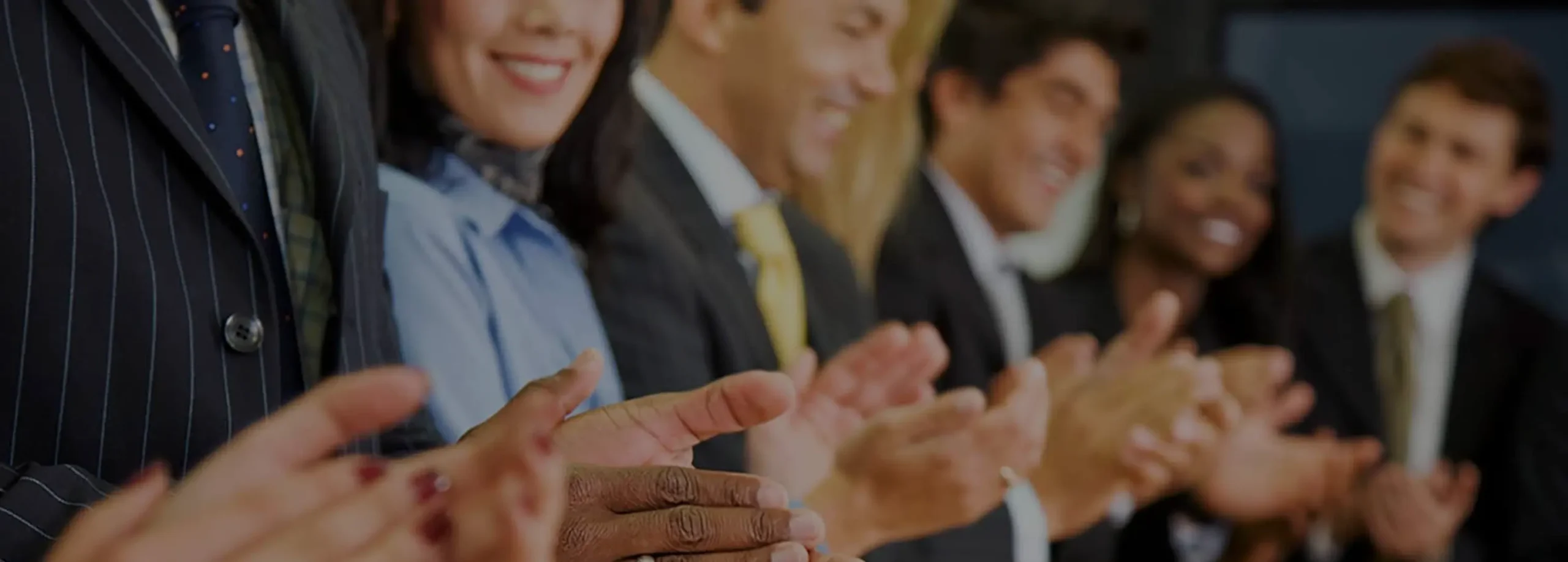 row of people wearing suits clapping their hands